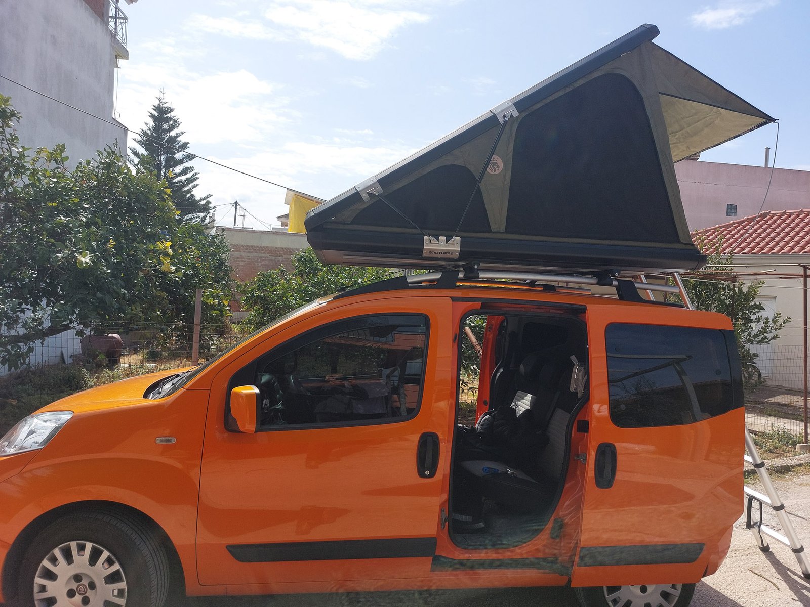 brotherscamp-aluminium-rooftop-tent-triangle (2)-2 Brothers Camp Triangle hard shell roof top tent mounted on a Fiat Qubo, side view with tent fully opened for overlanding and camping.